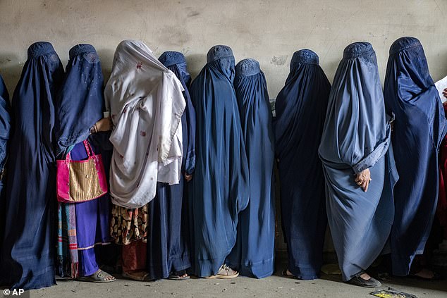 Afghan women wait for food rations to be distributed by a humanitarian aid group, in Kabul, Afghanistan, Tuesday, May 23, 2023