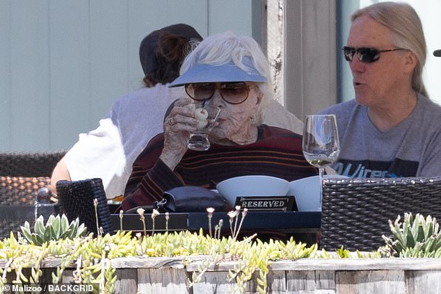 In addition to her meal, Shirley received what appeared to be a martini in a stemless glass, while a glass of white wine was also on the table.