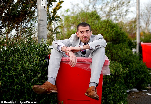 A racegoer sits in a box at the end of day two of the 2024 Randox Grand National Festival