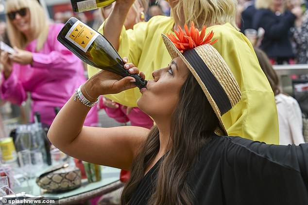 A woman is pictured drinking a bottle of bubbly at the event in Liverpool today