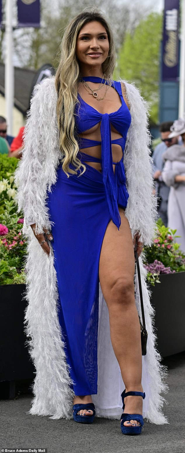 This partygoer wore a sapphire blue dress with a large slit that reached her thigh, paired with a fluffy coat