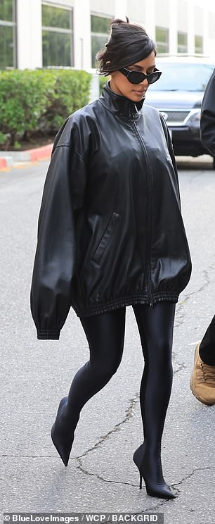 She added an oversized high-neck black leather jacket with the fashion house's name and logo on one side