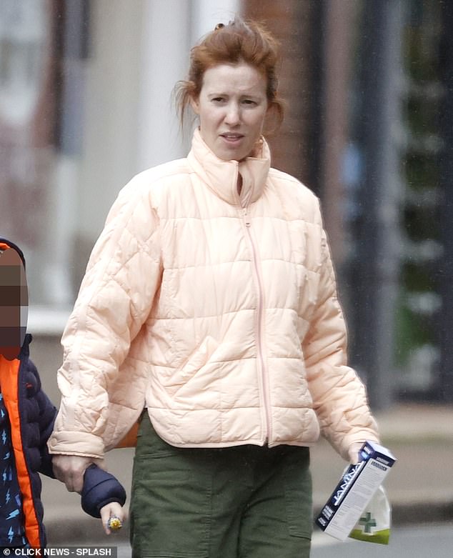 Appearing makeup-free, Amy embraced her natural look as she scraped her red locks from her face while running errands with the couple's son.