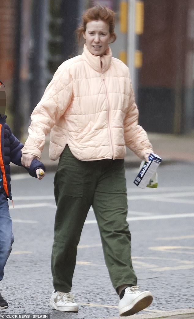 To keep it casual, she opted for a light salmon-colored padded jacket, dark green pants and sneakers