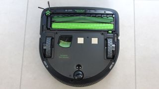 iRobot Roomba S9+ upside down on a tile floor