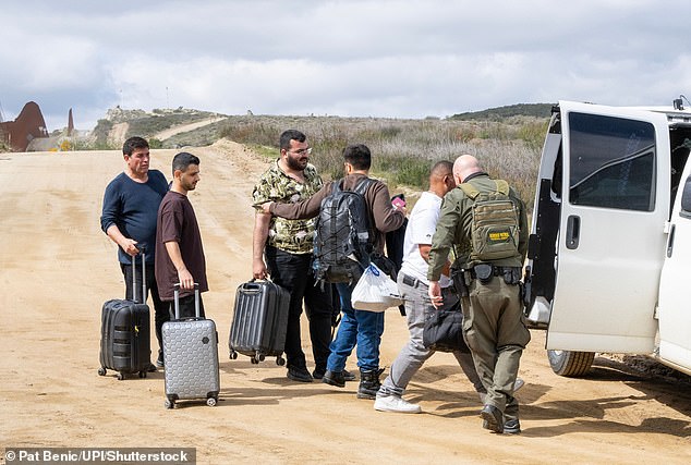 Migrants with hand luggage are stopped at the border in El Campo on March 13