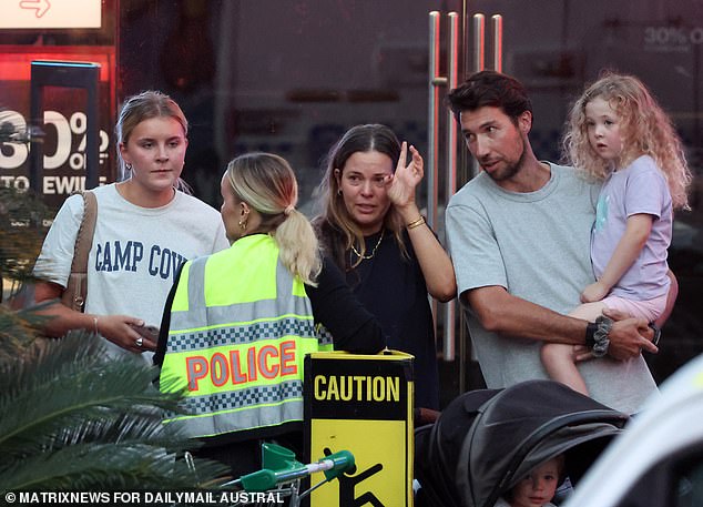 Cauchi's parents said: 'We are absolutely devastated by the traumatic events that have taken place in Sydney' (pictured, witnesses talking to an officer at the scene)