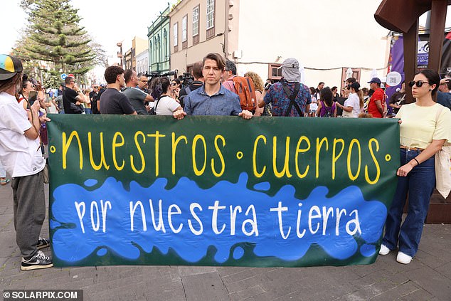 Anti-tourism protesters hold a sign that reads: 'Our bodies, for our country'