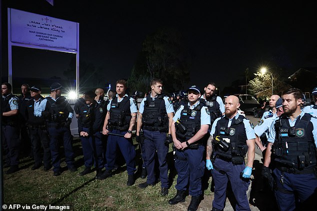 A group of police officers gather outside the church in Sydney's Wakeley