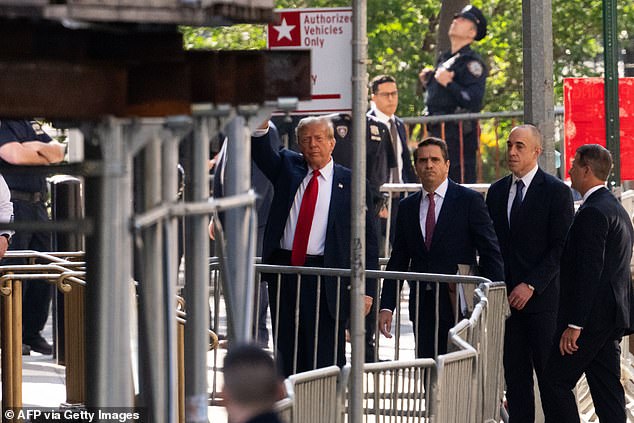 Trump walks into the Criminal Court in downtown Manhattan with lawyers Todd Blanche and Emil Bove and waves to the gathered crowd