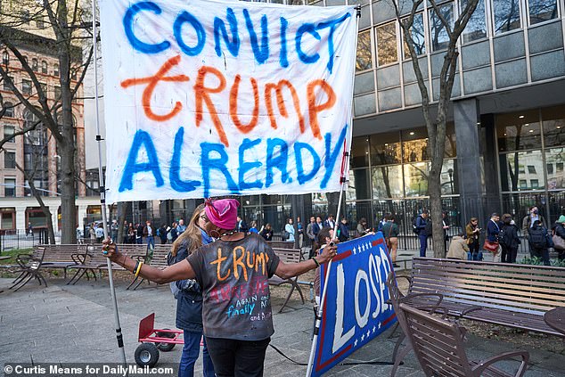 Anti-Trump protesters stand with large banners outside the Manhattan Criminal Court House at 100 Center Street in New York City on Monday awaiting the former president's arrival