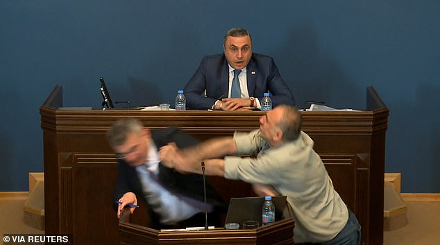 Video of the incident shows MP Aleko Elisashvili charging from the speaking politician's left, waving his fist and making contact with the man's face.  Another politician sitting behind the speaker looks on, open-mouthed and shocked