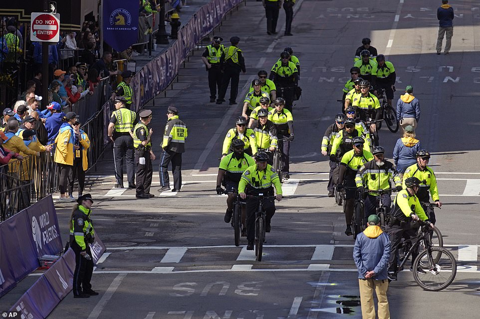 Police on bicycles approach the finish line of the Boston Marathon