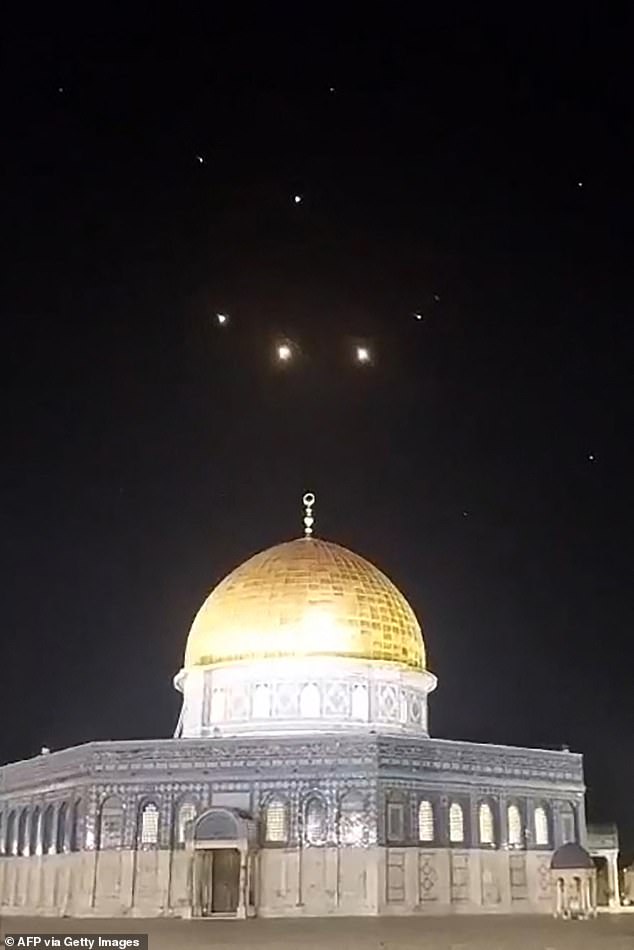 An image taken from a video taken early on April 14, 2024 shows rocket trails in the sky above the Al-Aqsa Mosque complex in Jerusalem