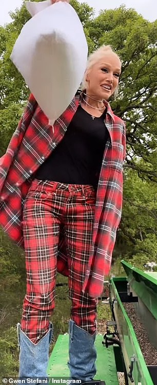 She wore a long red and black checked shirt with rolled up sleeves over matching checked pants and a black T-shirt.  The fashionista wore knee-high boots covered in light denim