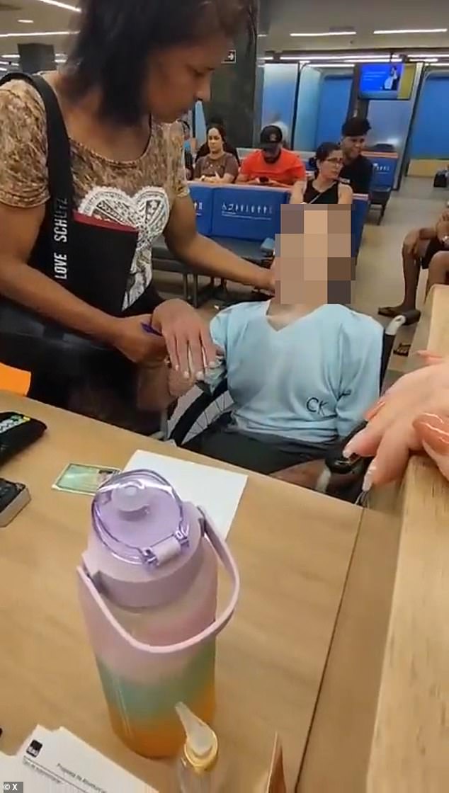 Footage showed the woman telling the dead man to grip his pen tightly as she placed it between his fingers and encouraged him to sign a piece of paper at the bank branch in Bangu, a neighborhood in western Rio de Janeiro, Brazil.