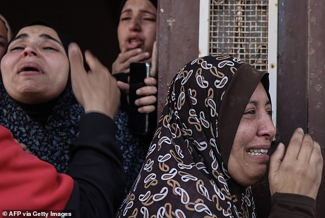 Palestinian women cry as the bodies of injured and killed relatives are taken from a residential building targeted in a nighttime bombardment in Rafah on April 2, 2024