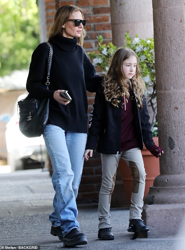 The 47-year-old reality star wore a black turtleneck, loose faded jeans and black boots while out with Phoenix, eight.