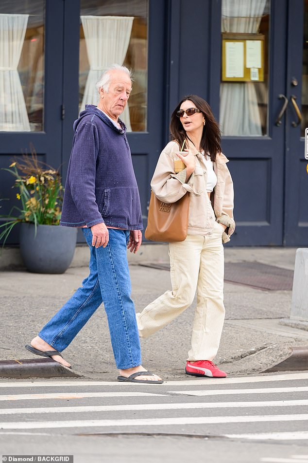 While sipping an iced coffee, Emily looked stylish in a white crop top, beige cords and a trendy utility jacket