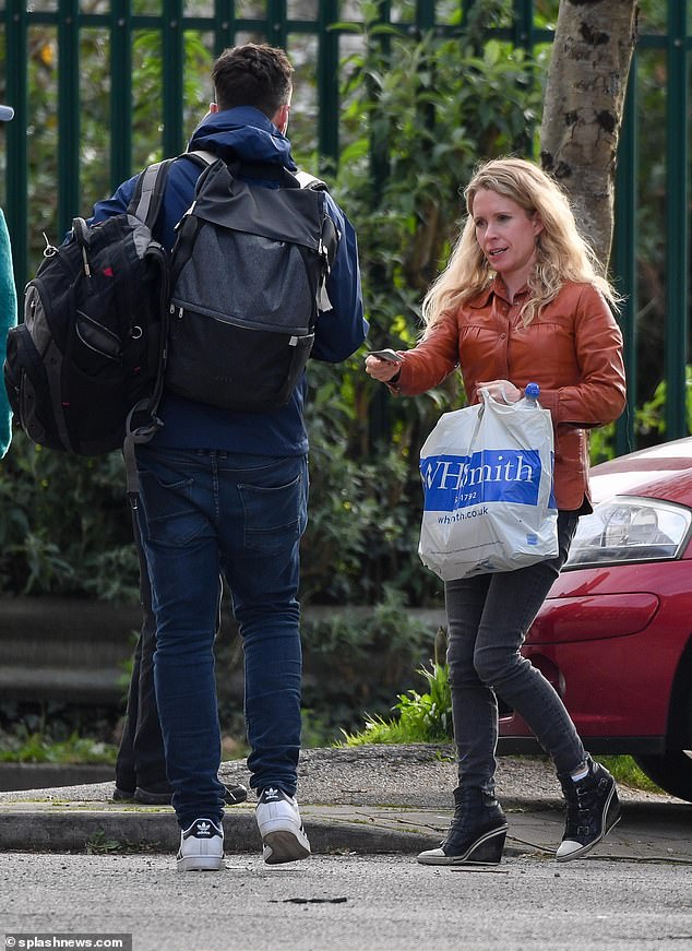 Lucy could be seen handing something to a male companion - who may have been a member of her team