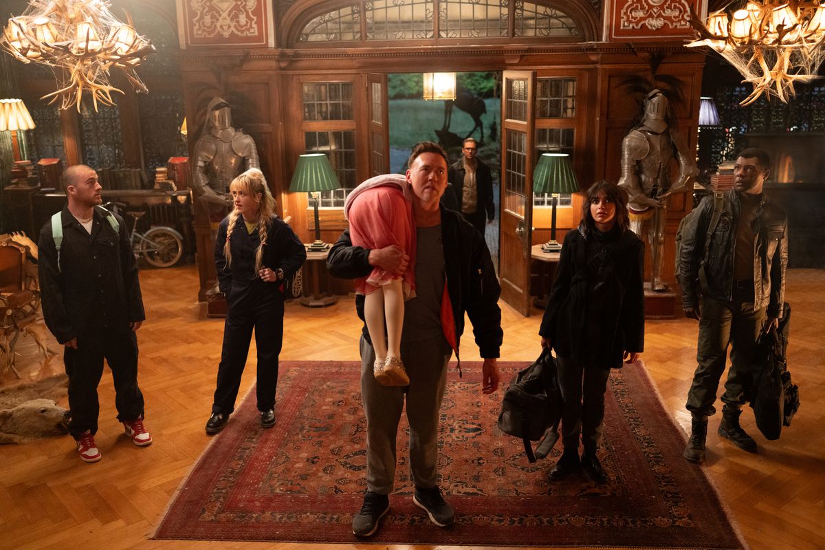 Kevin Durand, Alisha Weir, Kathryn Newton, Dan Stevens, Melissa Barrera, Angus Cloud and William Catlett stand in the lobby of a swanky mansion in Abigail