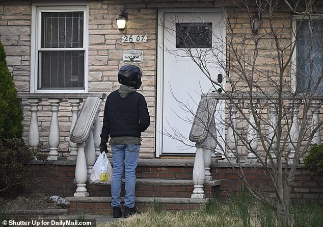 A delivery person waits at the front of the house after the squatters have ordered food inside