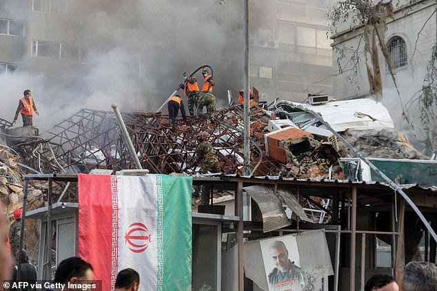 Emergency services and security personnel extinguish a fire at the site of the attack that hit the Iranian embassy in the Syrian capital Damascus on April 1, killing 13 people, including two Islamic Revolutionary Guard Corps generals.