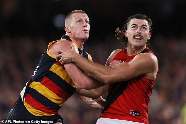 Draper tangles with the Crows' Reilly O'Brien during the thrilling clash at Adelaide Oval