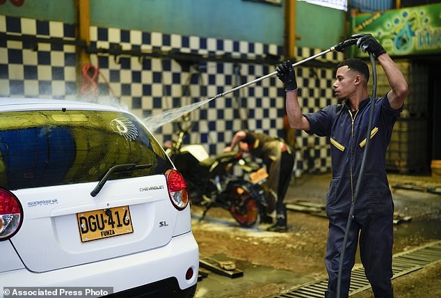 A worker washes a car at an ecological car wash in Bogotá, Colombia, on April 12.  Water rationing in the capital began on April 11 due to low water levels in the reservoirs that supply the capital with drinking water, a consequence of the El Niño weather phenomenon