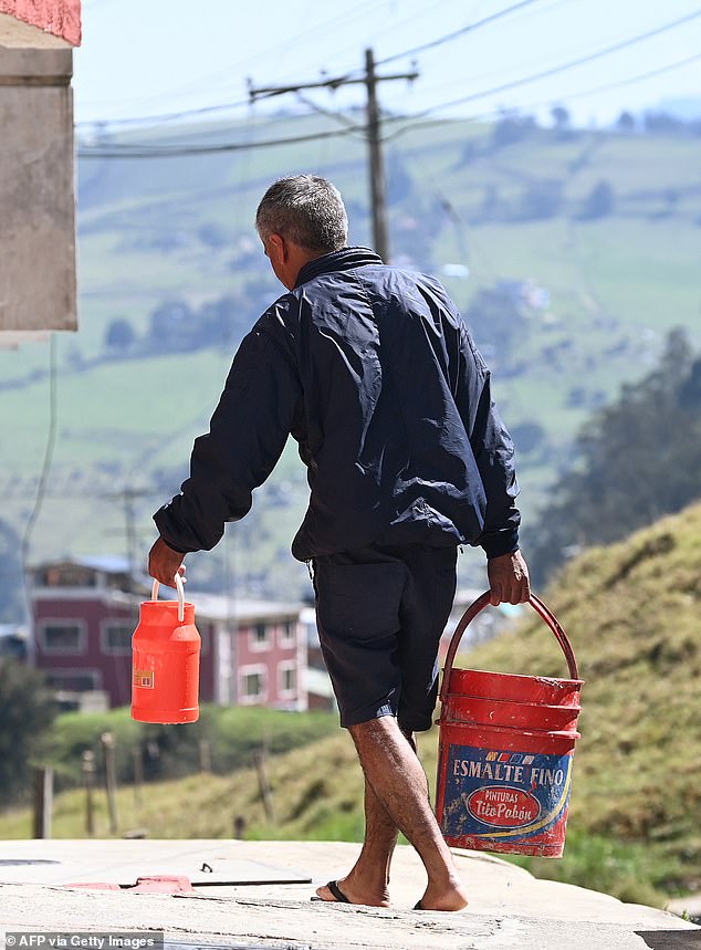 A resident of La Calera, a city north of Colombia's capital Bogotá, brings water to his home.  The area is facing a water shortage as the main reservoirs have been affected by the drought that has lasted for several months