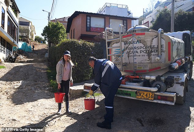 A resident collects water from a water truck in La Calera, a city near Bogotá, the capital of Colombia
