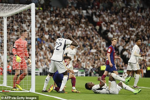 Real Madrid's German defender No. 22 Antonio Rudiger reacts as Real Madrid's Brazilian striker No. 07 Vinicius Junior lies on the pitch during the Spanish football match between Real Madrid CF and FC Barcelona at the Santiago Bernabeu Stadium in Madrid on April 21, 2024. (Photo by OSCAR DEL POZO / AFP) (Photo by OSCAR DEL POZO/AFP via Getty Images)