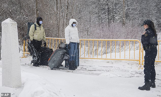 An RCMP officer stops people as they enter Canada via Roxham Road at the Canada-US border in Hemmingford, Quebec, Canada, on Saturday, March 25, 2023