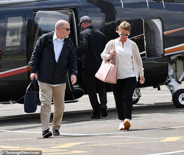 An assistant could be seen carrying a navy blue bag, while Melinda carried her own pink bag