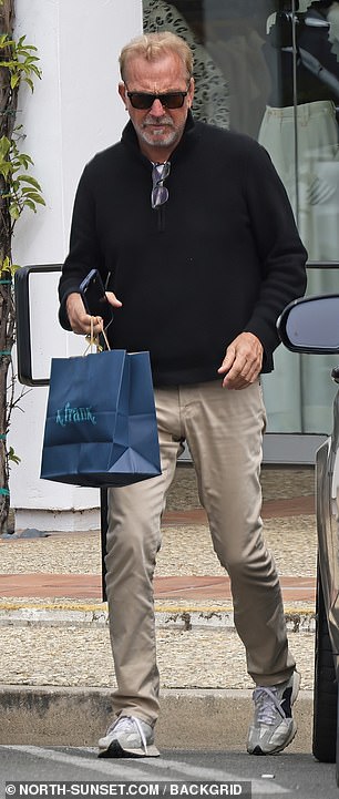 He was pictured leaving the store with a blue shopping bag in hand