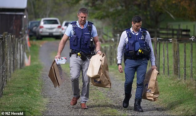 Police are pictured with evidence bags on the property where the retired couple died