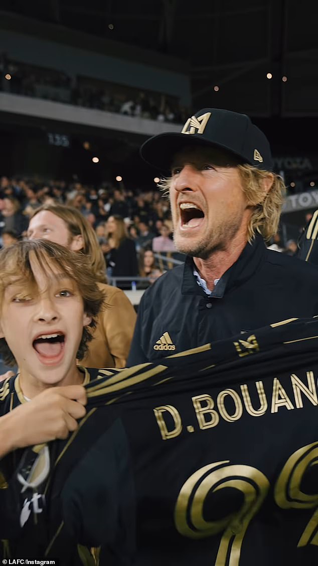 Wilson and his sons celebrated LAFC striker Denis Bouanga's football jersey with the number 99 in hand