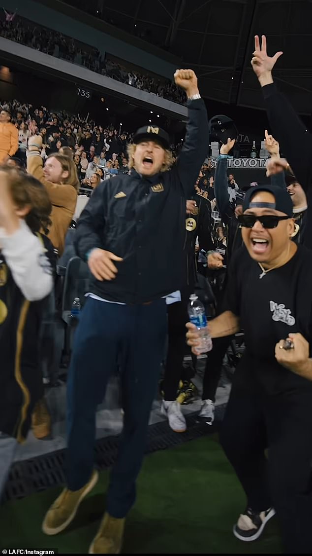 Wilson supported the home team in a team-branded ball cap and windbreaker, navy blue pants and brown shoes