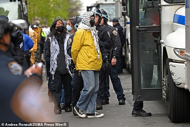 Buses full of protesters were marched away as students hurled insults at NYPD officers