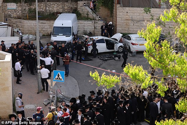 Israeli police cordoned off the site of the suspected 'terrorist attack' as several Jewish community members gathered to glimpse the aftermath