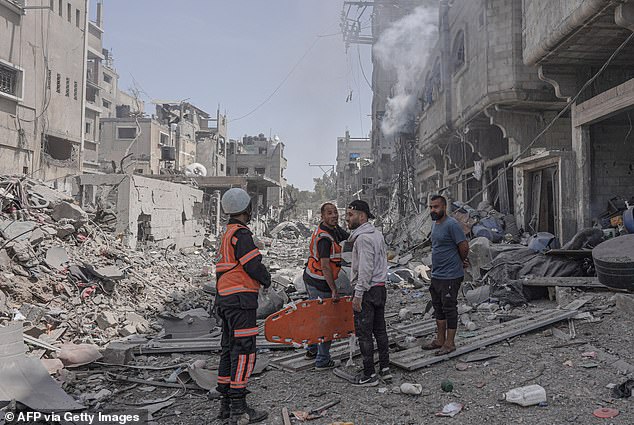 Palestinian medics gather at the site of an Israeli attack in the central Gaza Strip on April 22, 2024