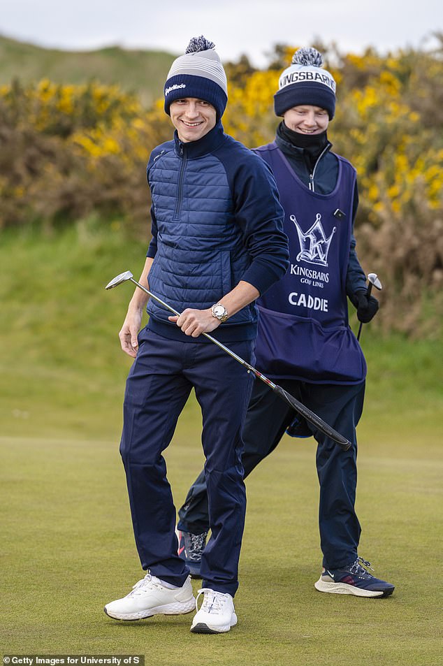 Bracing the Scottish wind, the Spiderman star wrapped himself in a blue padded jacket and matching blue trousers before donning a baseball cap