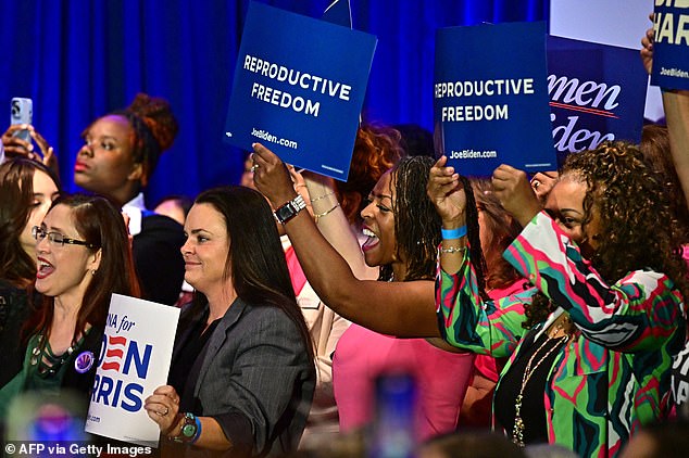 Women hold signs as they listen to US Vice President Kamala Harris' speech on abortion rights