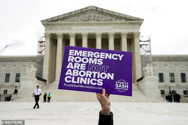 An anti-abortion activist holds a sign before oral arguments on Idaho's near-total abortion ban