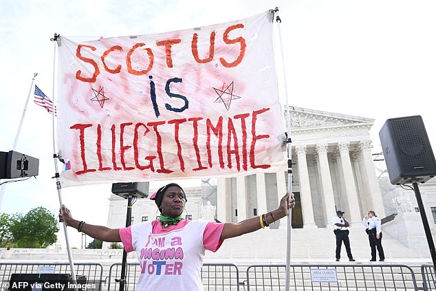 An abortion rights activist stands outside the Supreme Court on Wednesday morning