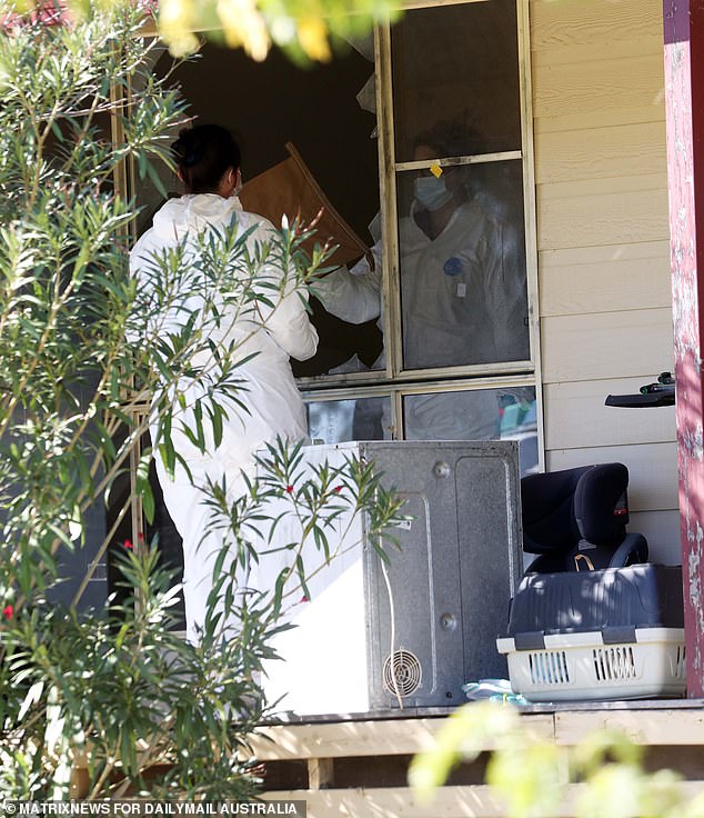 Forensic investigators are pictured at Molly Ticehurst's home on Tuesday.  The windows were destroyed