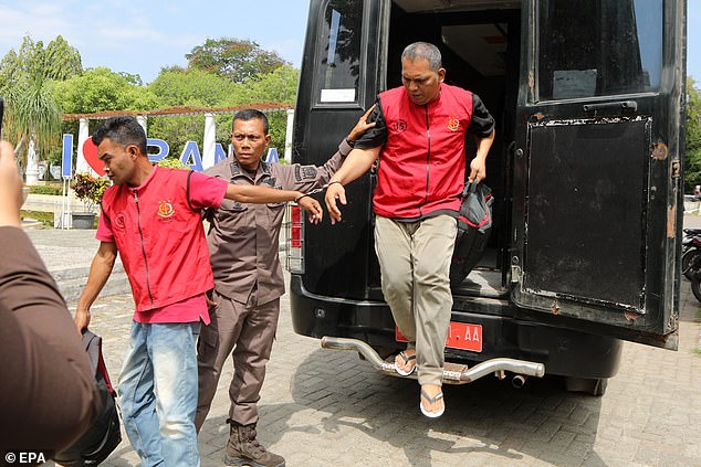 Two of the alleged religious lawbreakers are handcuffed together as they are escorted to their sentences by the prosecutor