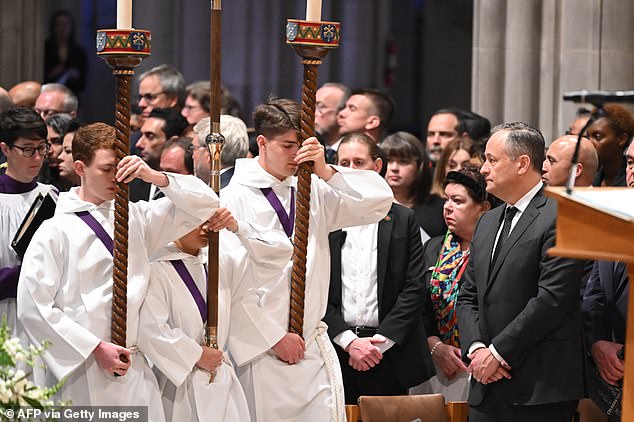 Second Gen. Doug Emhoff watches the procession to the National Cathedral at the top of Thursday's memorial for the seven World Central Kitchen workers who died feeding people in Gaza