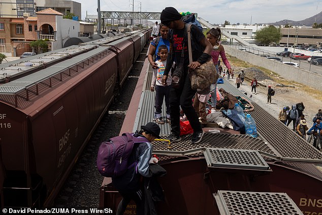 Migrants riding atop La Bestia disembark from the locomotive as they arrive at the southern U.S. border on Wednesday