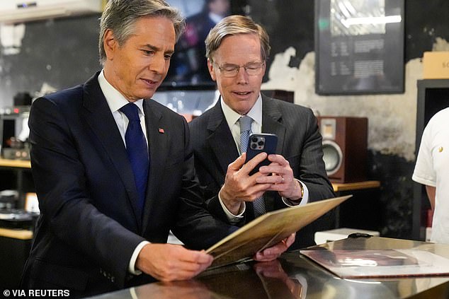 US Secretary of State Antony Blinken and US Ambassador to China Nicholas Burns view a record during a visit to the Li-Pi record store in Beijing